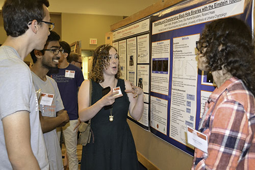 Bridgette Davey cheerfully goes over the results of her team's research with other students.